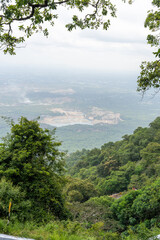 Obraz premium A mountain range with a forest and a city in the distance