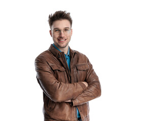 portrait of handsome young man with glasses crossing arms and smiling