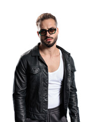 Obraz premium cool young man with sunglasses in black leather jacket looking forward