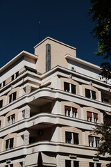 Modernist residential building with balconies and geometric facade under a clear blue sky in Belgrade, Serbia.