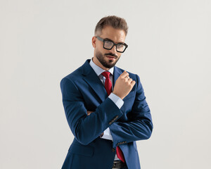 handsome elegant man with glasses folding arms and looking forward