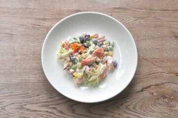 imitation crab stick with corn and garden pea couple cabbage vegetable topping shrimp egg salad dressing cream sauce on plate