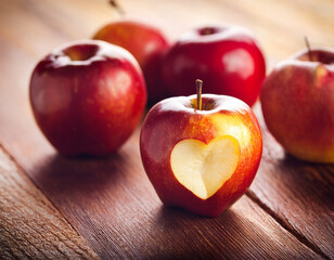 Fresh Red Apples with a Heart-Shaped Cutout on Rustic Wooden Table