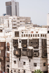 Contrast between old buildings with wooden windows in Al Balad Jeddah and modern skyscrapers in the background