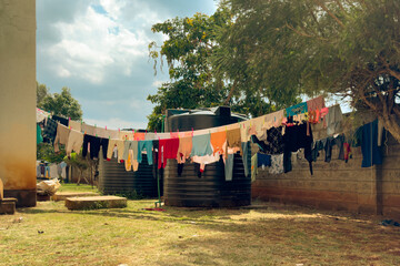 Assorted clothes on a clothesline amidst water tanks behind residential apartments 