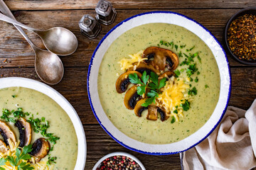 Creamy mushroom soup on wooden table. Top view