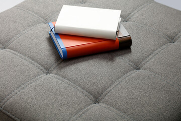 a close up of a beige sofa with tufted upholstery and neatly stitched square patterns.