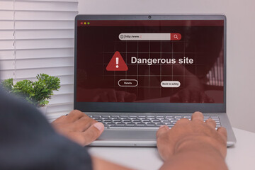 Dangerous site warning on laptop computer. A man visit a website indicates malware, phishing or...