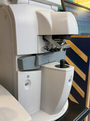 A white machine with a green button on it