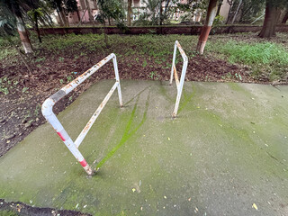 A pair of metal railings are leaning against each other on a concrete surface
