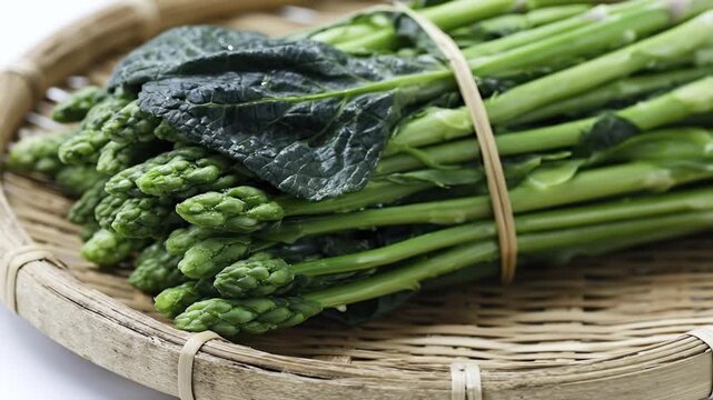 A pristine bundle of vibrant, fresh green vegetables, resembling broccoli or tenderstem varieties, is artfully arranged within a rustic woven basket. Each stalk is tied neatly with natural twine, emph