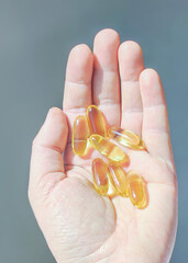Omega 3 capsules on a woman's palm.
