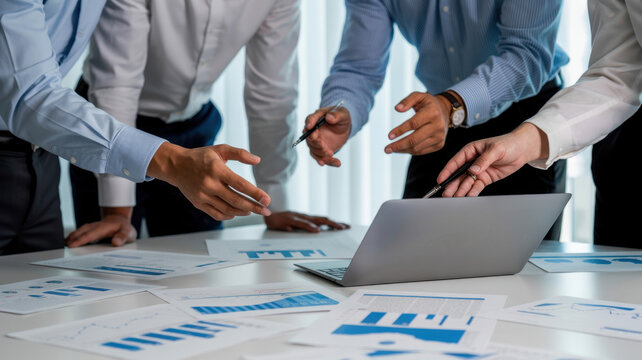 Business people analyzing company financial report working with documents and laptop in the office, discussing project and brainstorming ideas
