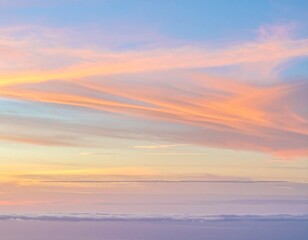 Fototapeta premium A serene and ethereal view of a pastel-colored sky at sunrise with soft, wispy clouds above a thick blanket of fog.