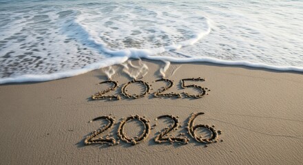 The years 2025 and 2026 written in the sand on a beach near the ocean