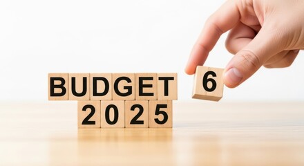 Budget 2025 concept with wooden blocks and hand placing number six on table
