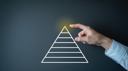Mans hand pointing to the top of a pyramid chart, representing achieving the highest level or reaching the top of a hierarchical structure