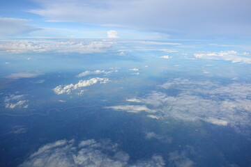 Fototapeta premium Beautiful white clouds drifting peacefully in the blue sky as seen from above or Layers of soft clouds stretching across the sky during a daytime flight.