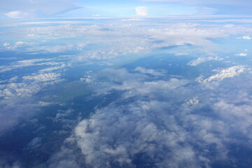 Beautiful white clouds drifting peacefully in the blue sky as seen from above or Layers of soft clouds stretching across the sky during a daytime flight.