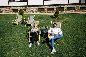 Obraz premium Young couple relaxing on loungers in the sun
