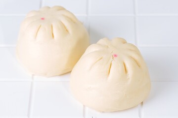 Two baozi buns served on white plate. Traditional Asian dim sum and snack bread. Popular breakfast...