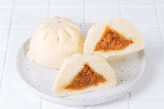 Close up of baozi buns showing savory meat filling. Traditional steamed bread dim sum snack from Asia.