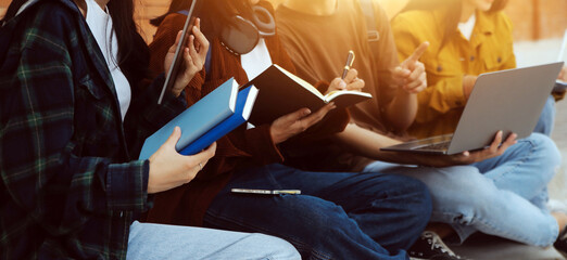 Happy students walking together on university campus, chatting and laughing outdoors after classes
