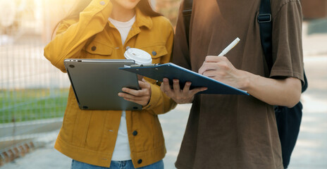 Happy students walking together on university campus, chatting and laughing outdoors after classes