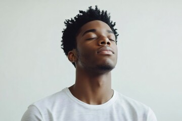 Obraz premium Young African American man with closed eyes deeply meditating, focusing on mindfulness and mental well being, radiating relaxation and spiritual peace