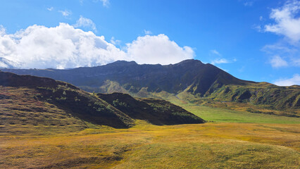 Fototapeta premium Mountain landscape with vast green valley and blue sky, Savoie, France, Europe.