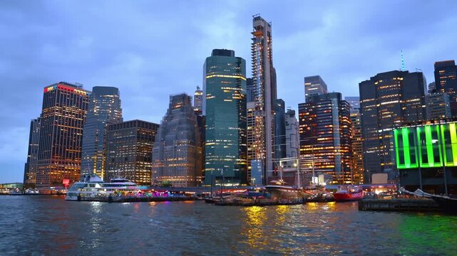 Stunning architecture of modern New York from the riverscape. Travel by the East River at dusk time.