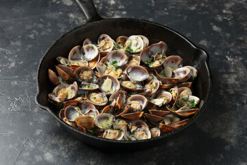 Steamed Clams with garlic, parsley and white wine in a cast iron pan