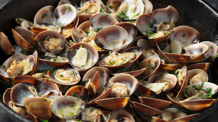 Steamed Clams with garlic, parsley and white wine in a cast iron pan