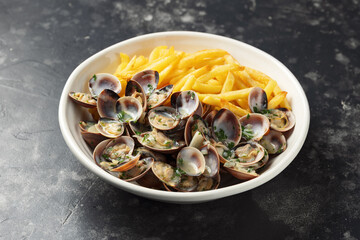 Steamed Clams with herbs and French fries in a white plate