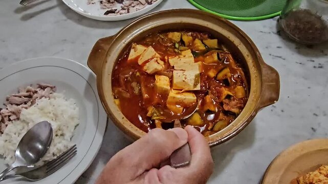 hands holding a bowl of dried fruits, Kimchi jjigae or Kimchi soup in ceramic bowl
Korean kimchi stew.Korean traditional food,Sundubu jjigae
