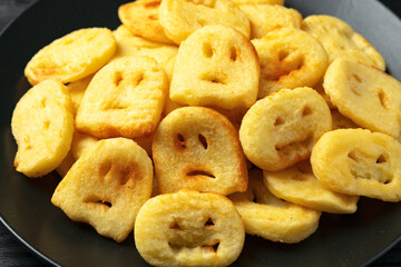 Fried Halloween potato shapes on black plate.