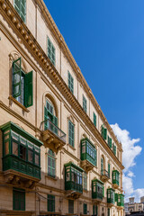 Naklejka premium Green Traditional Maltese Balconies on Sunlit Historic Building