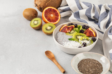 Healthy breakfast bowl with chia pudding, kiwi, blood orange, and berries