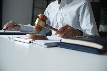 Legal justice man working on desk reading supportive documents to determine the case.