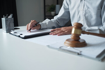 Legal justice man working on desk reading supportive documents to determine the case.