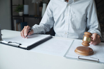 Legal justice man working on desk reading supportive documents to determine the case.