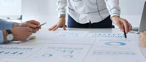 Business team analyzing financial charts during strategy meeting, professionals discussing data and performance metrics at workplace for decision making success