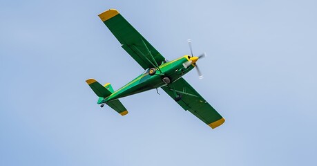 Green and yellow airplane flying in a clear blue sky today