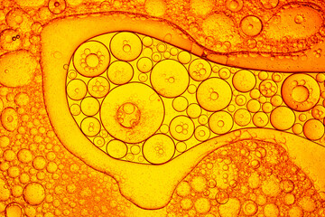 Macro distant yellow fuel bubble texture,Macro abstract image of golden oil bubbles suspended in liquid, forming overlapping circular patterns. The texture and light create a warm, artistic background