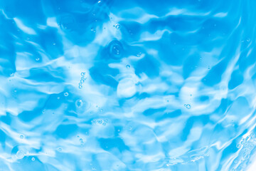 Transparent blue clear water surface texture with ripples, splashes and bubbles. Abstract summer banner background Water waves in sunlight with copy space Cosmetic moisturizer micellar toner emulsion