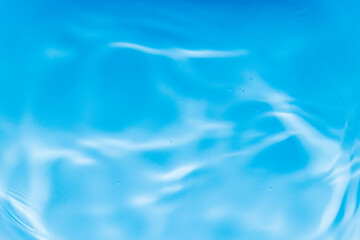 Transparent blue clear water surface texture with ripples, splashes and bubbles. Abstract summer banner background Water waves in sunlight with copy space Cosmetic moisturizer micellar toner emulsion