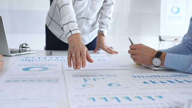Business team analyzing financial charts and graphs during corporate meeting, focusing on strategy development, data driven decision making, growth and planning