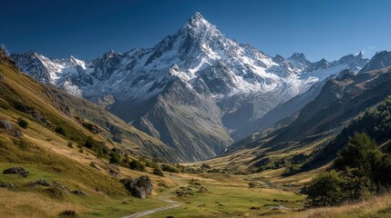 Obraz premium Majestic snow-capped mountains overlooking a serene, sprawling valley with winding trails