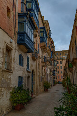Narrow Alley with Blue Maltese Balconies and Potted Greenery