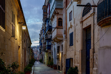 Blue-Hour Alley with Traditional Balconies, Warm Lanterns and Textured Limestone